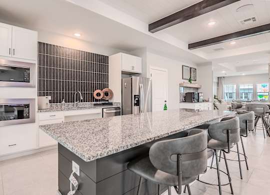 A modern kitchen with a granite countertop and stainless steel appliances.