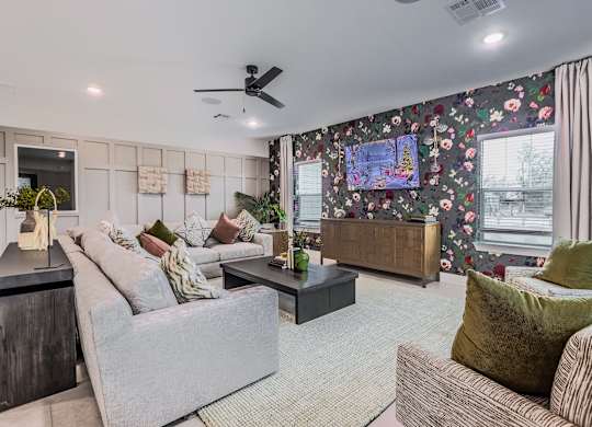 A living room with a grey sofa, a green cushion and a wooden side table.