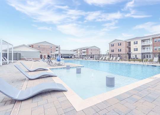 A swimming pool with a slide and a building in the background.