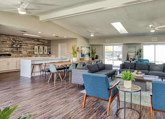 A modern living room with a kitchen area in the background.
