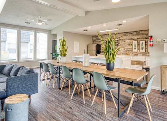 A modern dining room with a long table and chairs.