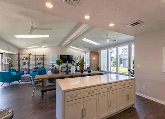 A kitchen with a white counter and blue chairs.