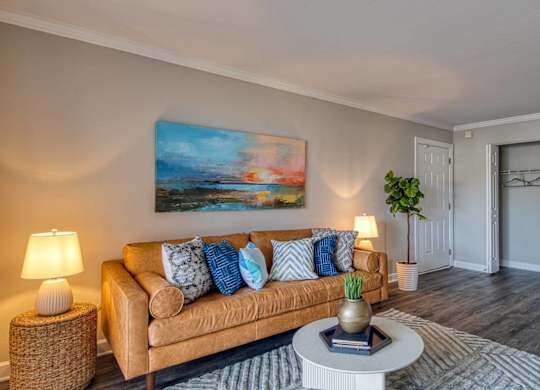 A living room with a couch, a side table, a coffee table, and a painting on the wall.