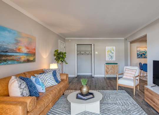 A living room with a brown couch, a coffee table, and a painting on the wall.