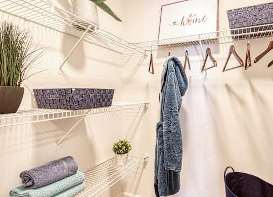 A white shelf with a hanger and a towel hanging on it.