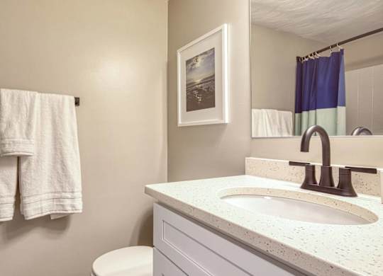 A white towel is hanging on a wall next to a white sink.