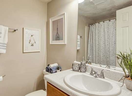 A bathroom with a white sink, towel rack, and a mirror.