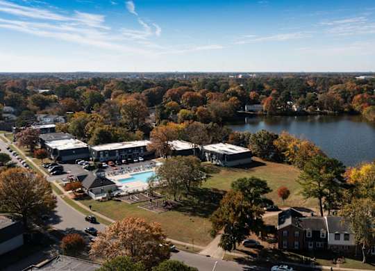 A large body of water surrounded by trees and buildings.