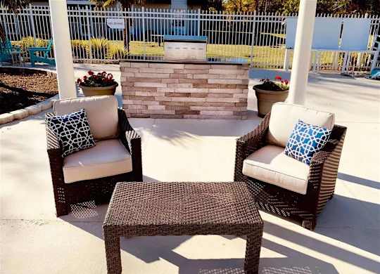 A patio set with a white cushion and a brown wicker table.