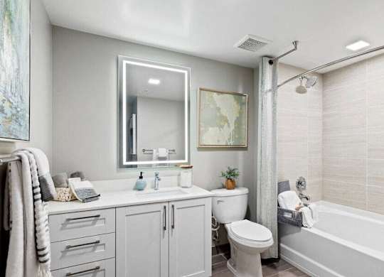 a bathroom with a tub sink toilet and a mirror at Mayla Pompano, Pompano Beach, 33062
