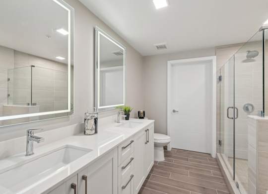 A bathroom with a white sink, mirror, and toilet.