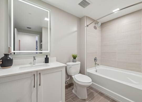 A white bathroom with a toilet, sink, and bathtub.