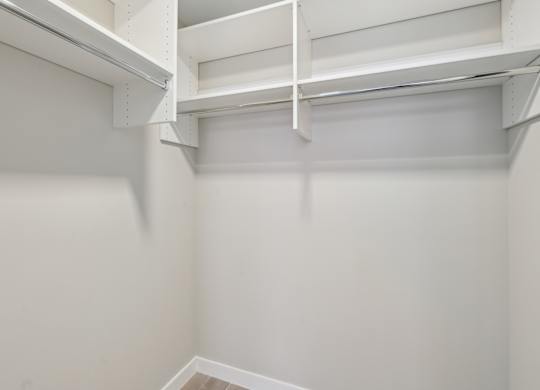 A white empty room with a shelf on the wall.
