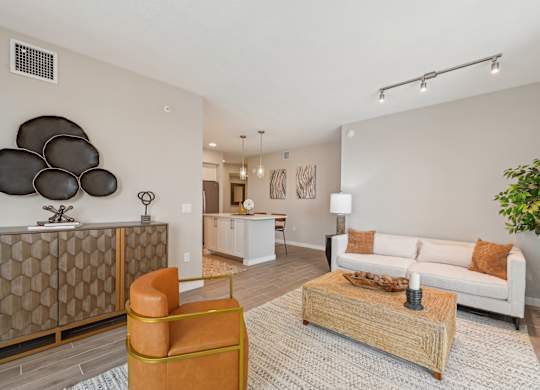 A living room with a white couch, a wooden coffee table, and a large abstract sculpture on the wall.