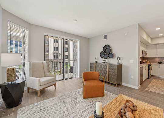 A living room with a sofa, chairs, and a rug.