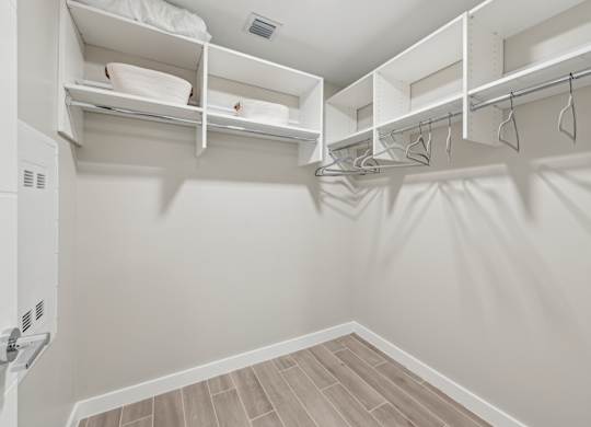 A white closet with shelves and hangers.