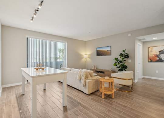 A living room with a white couch, a wooden coffee table, and a painting on the wall.