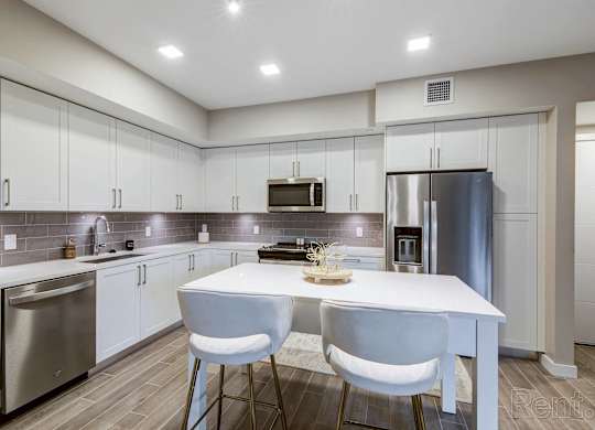 A modern kitchen with a white table and chairs.