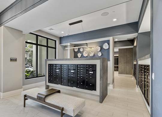 A modern waiting room with a bench and a wall of lockers at Mayla Pompano, Pompano Beach, Florida