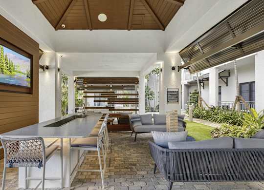 A modern outdoor dining area with a table and chairs at Mayla Pompano, Pompano Beach, FL, 33062