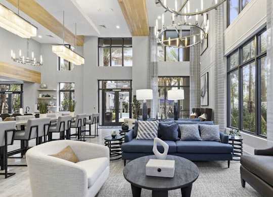 A modern living room with a variety of seating options and a chandelier.