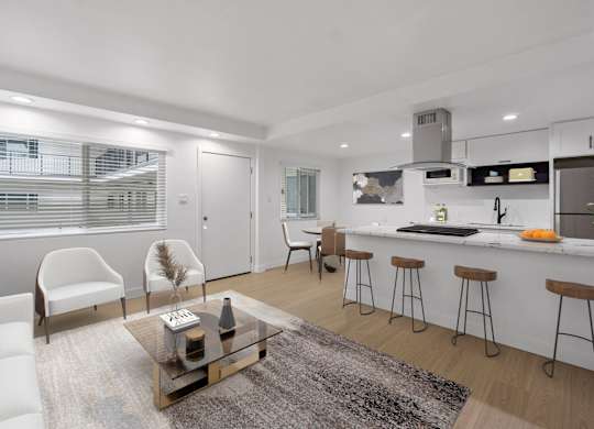 A modern kitchen with white cabinets and a bar area.