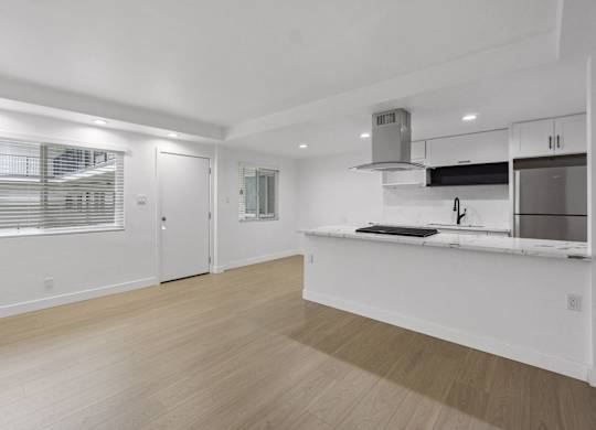 A kitchen with white cabinets and a wooden floor. at Torrance Gateway Apartments, California, 90501