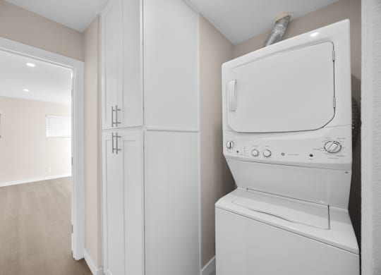 A white dryer is sitting in a laundry room.