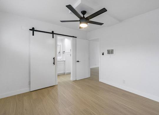 A room with a ceiling fan and wooden flooring. at Torrance Gateway Apartments, Torrance, California