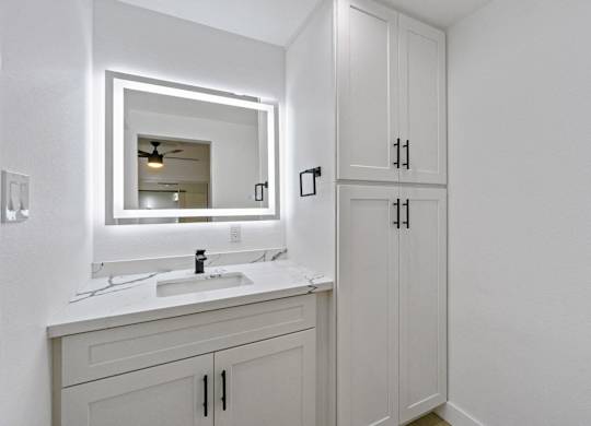 A bathroom with a white sink and a mirror. at Torrance Gateway Apartments, California, 90501