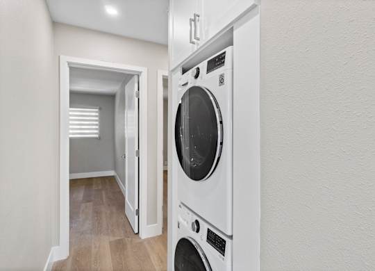 A white washing machine is in a small room.