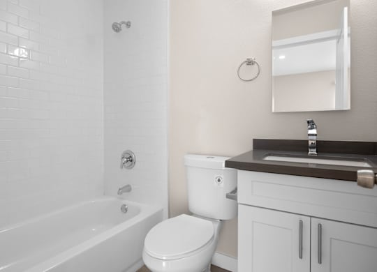 A white bathroom with a toilet, sink, and tub.