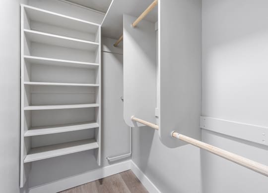 A white shelving unit with a white wall and a white rail.