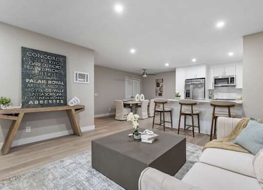 A living room with a coffee table and a chalkboard on the wall at Tamarack Sands Apartment Homes, Carlsbad, CA, 92008