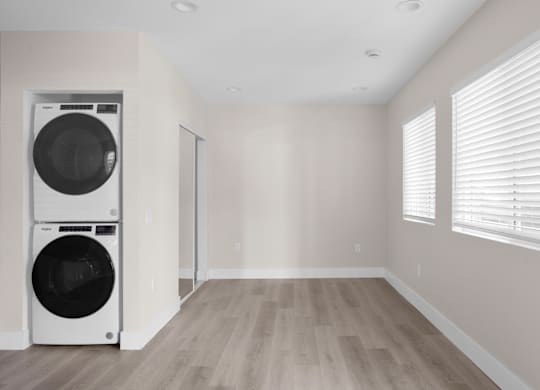 A laundry room with a washer and dryer stacked on top of each other.