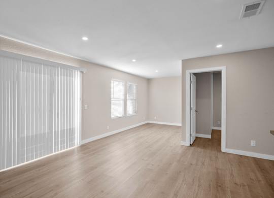 A room with a wooden floor and a sliding door.