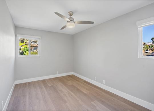 A room with a ceiling fan and two windows.at Ocean Edge @ Laguna Beach, Laguna Beach, 92651