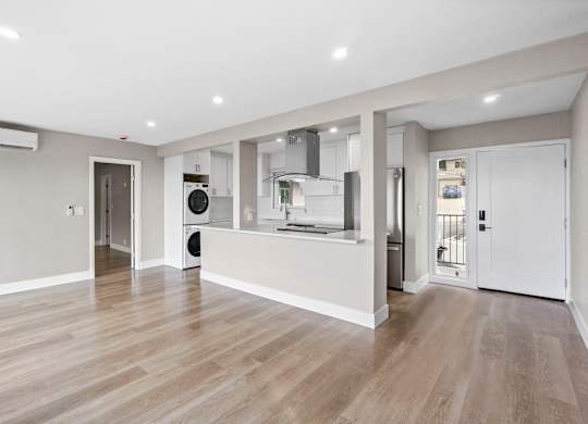 A spacious kitchen with a refrigerator, oven, and a sink.