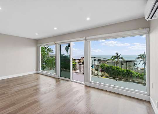 A room with a view of the ocean through large windows.