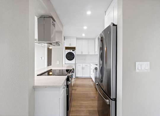 A modern kitchen with a refrigerator on the right side.