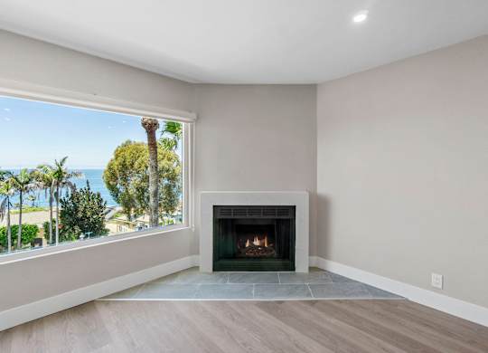 A modern living room with a fireplace and a view of the ocean.