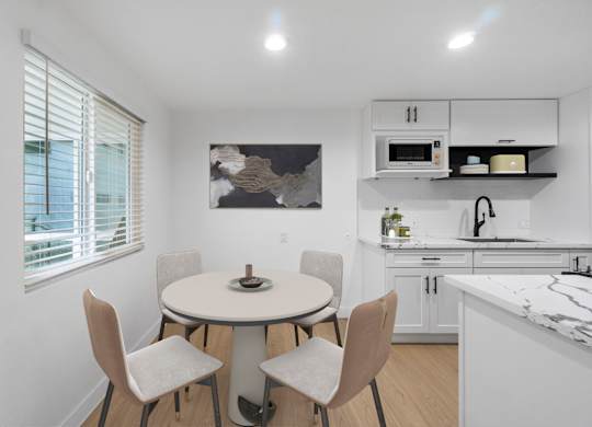 A kitchen with a table and chairs.