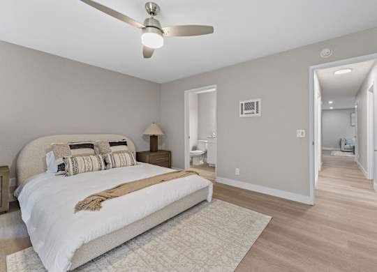 A bedroom with a large bed and a ceiling fan at Tamarack Sands Apartment Homes, Carlsbad, 92008