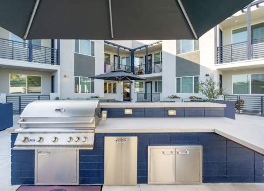 A modern outdoor kitchen with a grill and sink. at The Reserve La Mirada, La Mirada, California