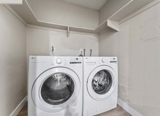 Two white front loading washing machines in a laundry room at Tamarack Sands Apartment Homes, Carlsbad, California