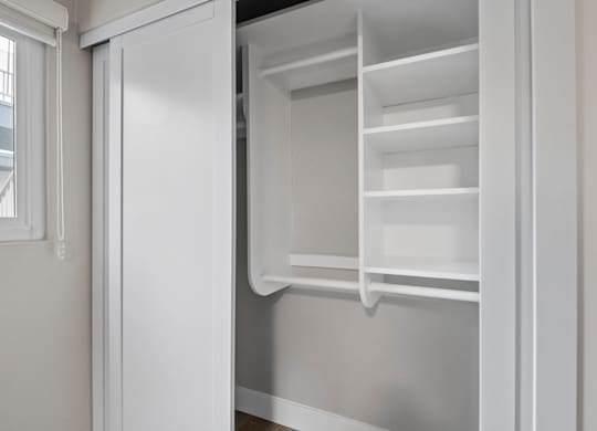 A white refrigerator with the door open and shelves inside.