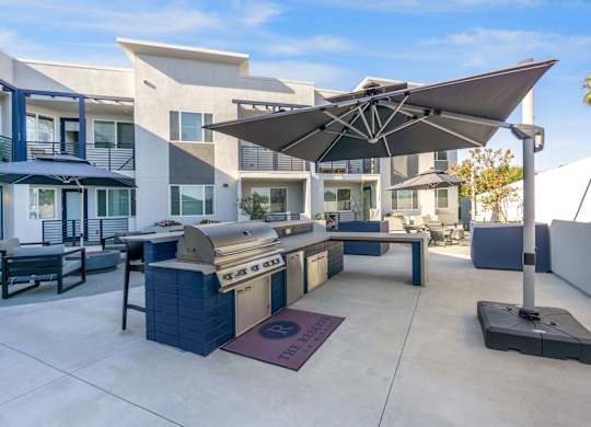 A modern outdoor kitchen area with a grill and seating area. at The Reserve La Mirada, La Mirada, 90638