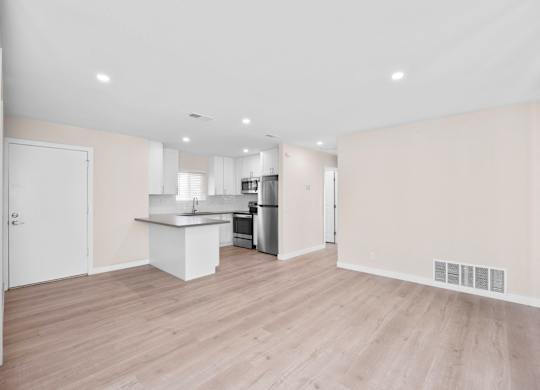 A kitchen with a white countertop and wooden flooring.