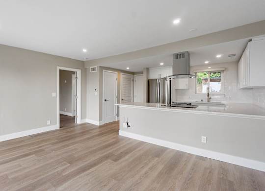 A kitchen with a refrigerator, sink, and cabinets.