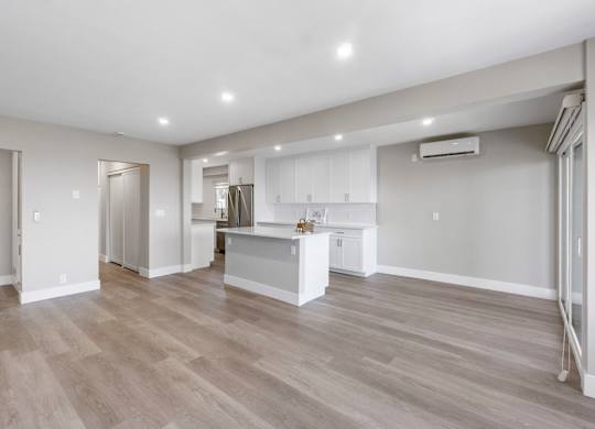 A spacious kitchen with a bar area and a dining table.